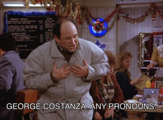 George Costanza From Seinfeld gesturing to himself with the caption: George Costanza, Any Pronouns